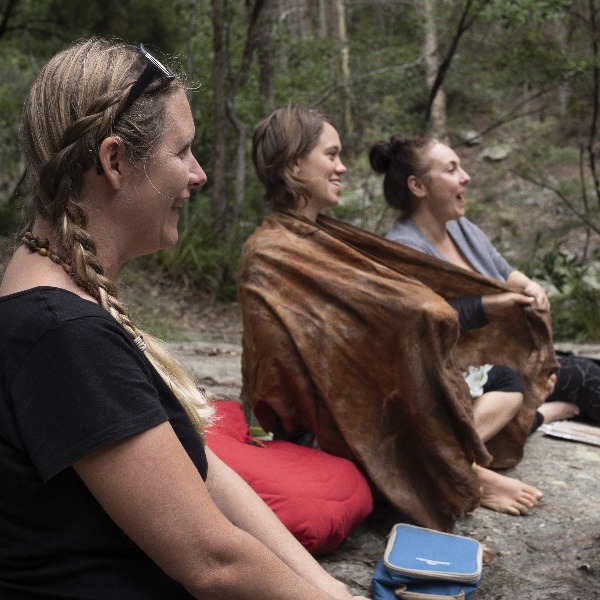 Inside Time Outside nature connection retreats for women. Three women sitting in a forest.